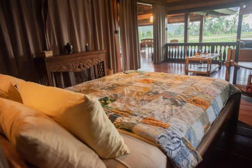 a bedroom with a bed with a quilt on it at Bali Eco Stay in Blimbing
