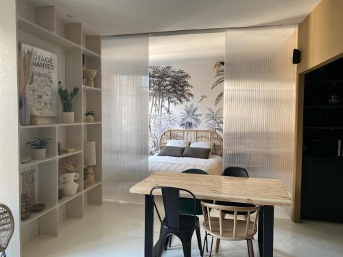 une salle à manger avec une table et un lit dans l'établissement Appartement cosy, Gare 5 minutes et Home cinéma, à Nantes