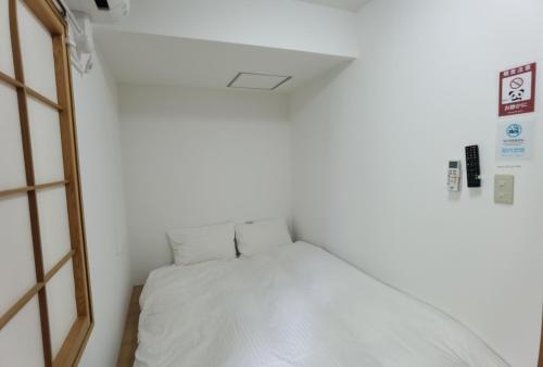a small room with a white bed in it at Hostel Belle Via Tokyo in Tokyo