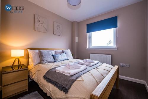 1 dormitorio con 1 cama con toallas en Stylish 3 Bed Apartment Aberdeen, en Aberdeen