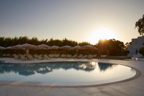 a pool with chairs and umbrellas at a resort at Absolute Kiotari Resort in Kiotari