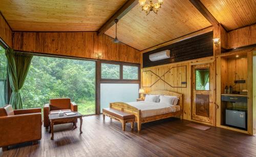 a bedroom with a bed in a room with wood walls at The Arboreal Resort in Āmbavna