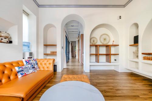 an orange couch in a living room with white walls at Yongyue 18 Homestay in Puli