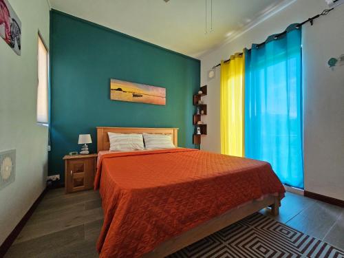 a bedroom with a bed and a blue wall at Villa Aahana - Flic en Flac in Flic-en-Flac