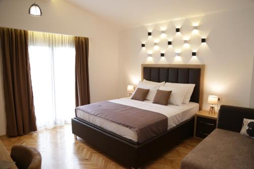 a bedroom with a large bed and a chair at Hotel Comfort & Villas in Donji &Scaron;toj