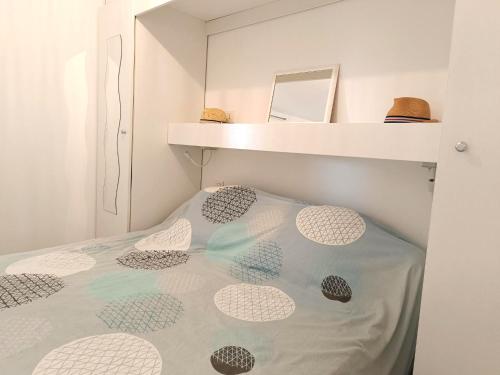 uma cama num pequeno quarto com uma prateleira em Ravissant T2 vue mer et massif - Les Clés de L´Estérel em Théoule-sur-Mer