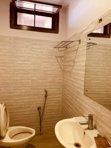 a bathroom with a toilet and a sink at Hotel Devika in Dibrugarh