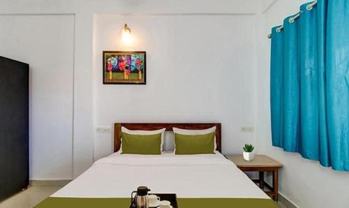 um quarto com uma cama grande e almofadas verdes em FabExpress Aqua Vista em Morjim