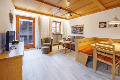 een woonkamer met een keuken en een woonkamer met een bureau bij Ferienwohnungen Gastager in Ruhpolding