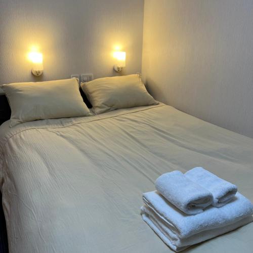 un letto bianco con due asciugamani pieghevoli sopra di Oda hotel Akihabara a Tokyo