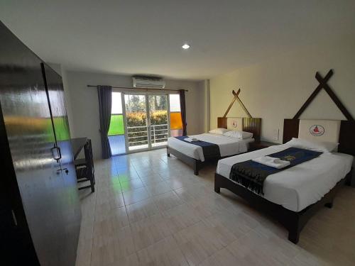 una camera con due letti e una grande finestra di Saensukkho Green Hotel & Resort a Chiang Rai