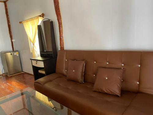 a brown couch in a living room with a tv at Kohjum Relax Beach in Ko Jum