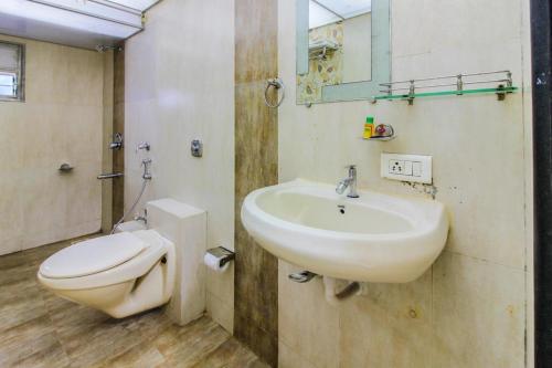 a bathroom with a sink and a toilet at Hotel Grand Corp Inn, Near Nesco Exhibition Center in Mumbai