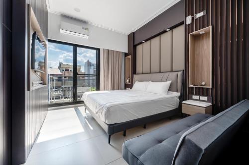 a bedroom with a bed and a couch and a window at Yongyue 18 Homestay in Puli