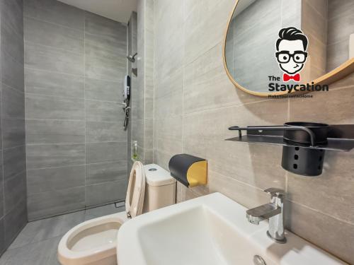 ein Badezimmer mit einem Waschbecken, einem Spiegel und einem WC in der Unterkunft Staycation Homestay 34 Kuching Riverine Petanak Resort in Kuching