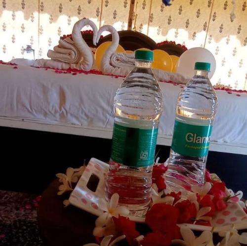 two bottles of water sitting on a table with a cake at Jaisal heritage desert camp in Jaisalmer