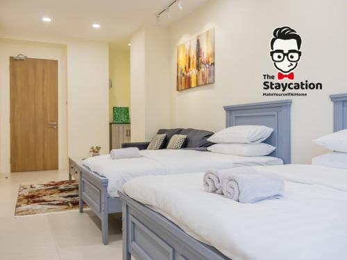 Zimmer mit 4 Betten und einem Schild an der Wand in der Unterkunft Staycation Homestay 34 Kuching Riverine Petanak Resort in Kuching