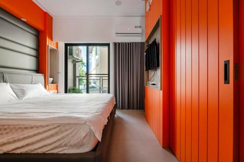 a bedroom with orange walls and a bed and a tv at Yongyue 18 Homestay in Puli