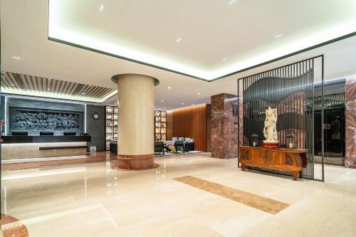 上海市にあるSSAW ブティック ホテル 上海 外灘の柱とテーブルのある広い部屋を備えたロビー