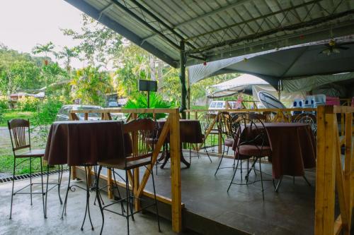 a group of tables and chairs under an umbrella at OYO 90037 The 7 Lodge Tambunan in Tambunan