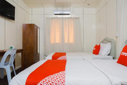 1 dormitorio con 2 camas con sábanas rojas y blancas en OYO 90037 The 7 Lodge Tambunan, en Tambunan