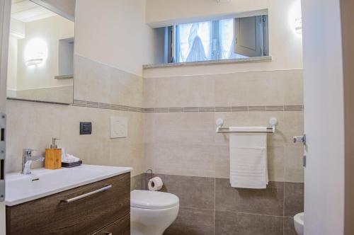een badkamer met een toilet, een wastafel en een spiegel bij Esclusivo Loft Centro Storico private garden E-Bike in Cherasco