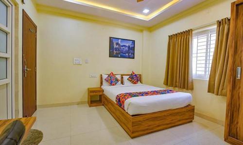 a bedroom with a large bed in a room at FabExpress Purple Suites Inn in Bangalore