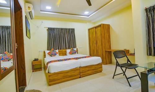 a bedroom with a bed and a desk and a chair at FabExpress Purple Suites Inn in Bangalore