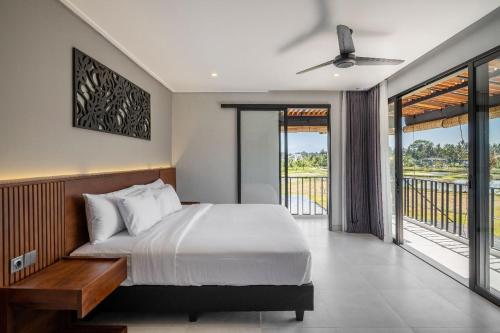 1 dormitorio con 1 cama y balcón en Villa Cakra. Modern villa with 4 Bedroom and infinity pool, en Ubud