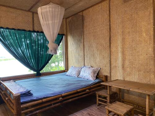 Zimmer mit einem Bett, einem Fenster und einem Tisch in der Unterkunft Farmstay Ao Nhà 