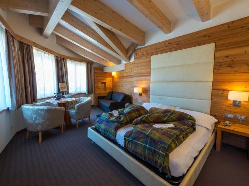 - une chambre avec un lit, un bureau et une chaise dans l'établissement Bio Hotel Brusago Vital & Wellness, à Bedollo