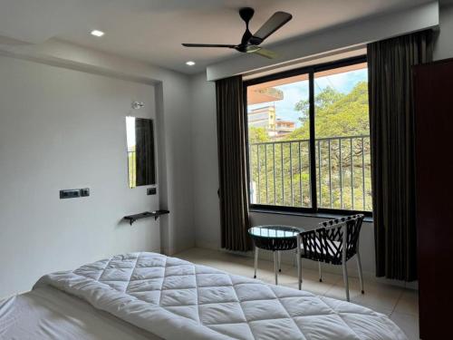 een slaapkamer met een bed, een tafel en een raam bij Balaji Inn Guest House, Panjim in Panaji