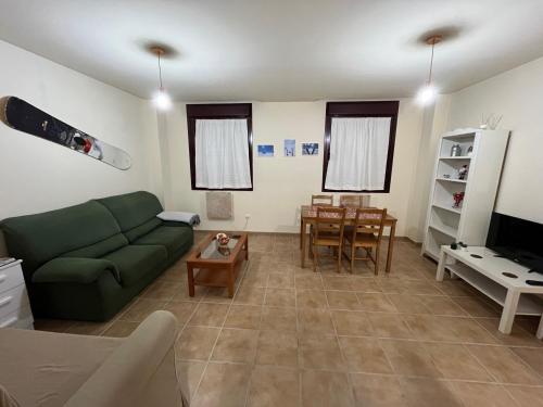 a living room with a green couch and a table at Precioso apartamento en San Isidro , ski , snow in San Isidro