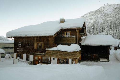 ein schneebedecktes Gebäude in der Unterkunft Margarethe Apartments Lech in Lech am Arlberg