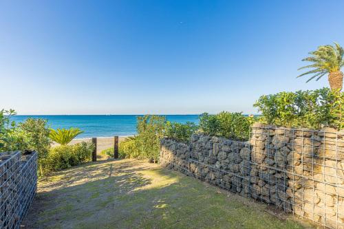 a stone wall with the beach in the background at amane in Kyonan