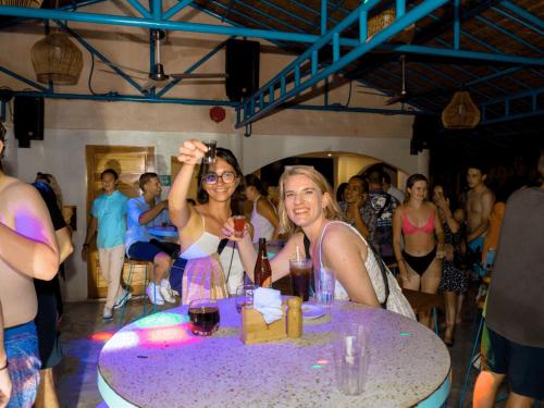 two women sitting at a table with wine glasses at Mad Monkey Panglao in Panglao