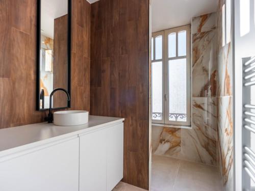 une salle de bain avec un lavabo et une fenêtre dans l'établissement Le Charmant de Medreville * Nancy, à Nancy