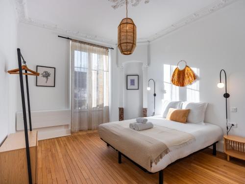 une chambre blanche avec un grand lit dans une pièce dans l'établissement Le Charmant de Medreville * Nancy, à Nancy