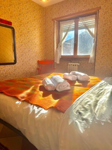 a bed with towels on top of it with a window at Rifugio Tra Le Vette in Bardonecchia