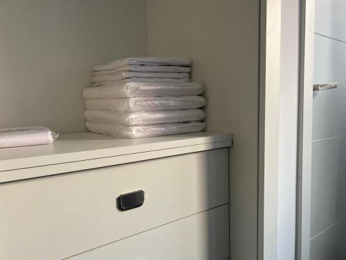 a stack of towels sitting on top of a dresser at Apartamentos para 10 personas en Barrio del Pilar in Madrid