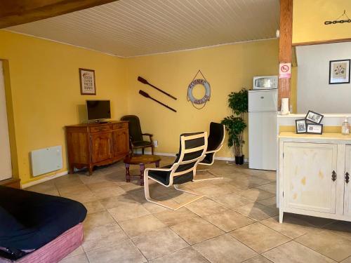 - un salon avec deux chaises et un réfrigérateur dans l'établissement Les Gites de La Vieille Roue - Gite 2, à Reignac