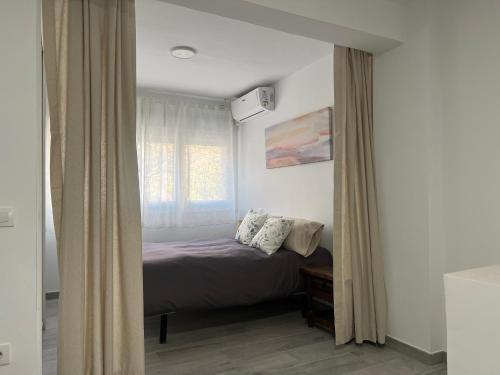 Apartamentos para 10 personas en Barrio del Pilar في مدريد: غرفة نوم بسرير ونافذة