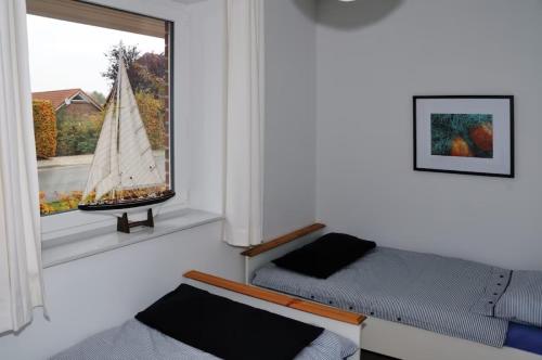 una sala de estar con sofá y un velero en una ventana en Landhaus Gericke, en Kappeln