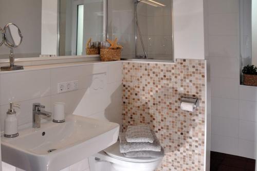 Un baño blanco con lavabo e inodoro. en Landhaus Gericke, en Kappeln