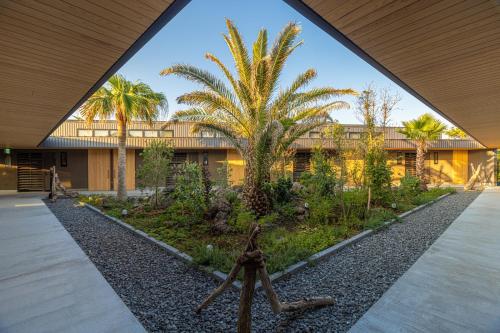 a building with palm trees in front of it at amane in Kyonan
