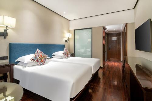 a bedroom with a large white bed and a television at SSAW Boutique Hotel Shanghai Bund in Shanghai