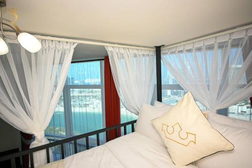 a bedroom with a white bed with a large window at Melody Studio Apartment Al reem. in Abu Dhabi