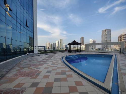 a large swimming pool on a building with a gazebo at Melody Studio Apartment Al reem. in Abu Dhabi