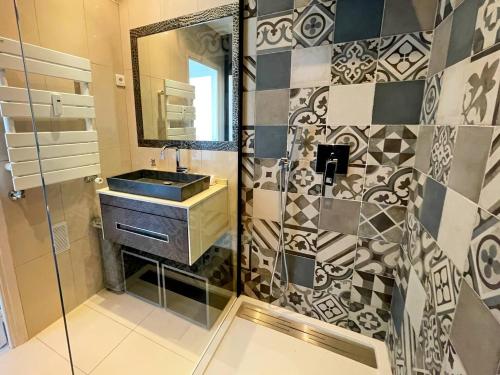 une salle de bain avec un lavabo et un miroir dans l'établissement Le Chaville, à Cagnes-sur-Mer