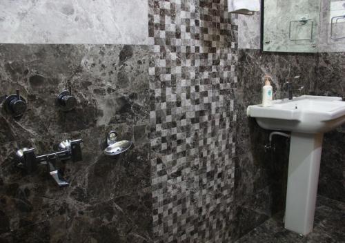 a bathroom with a sink and a mirror at The Sojourn in Dharamshala